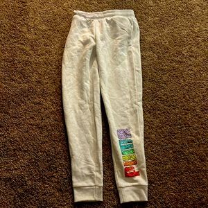 White/cream colored puma joggers w/ rainbow puma logo L-14/16